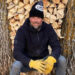 Josh Duhamel smiles as he poses in front of a stack of logs at his Minnesota home.