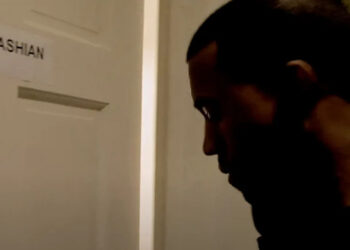 Ye stands near a door labeled