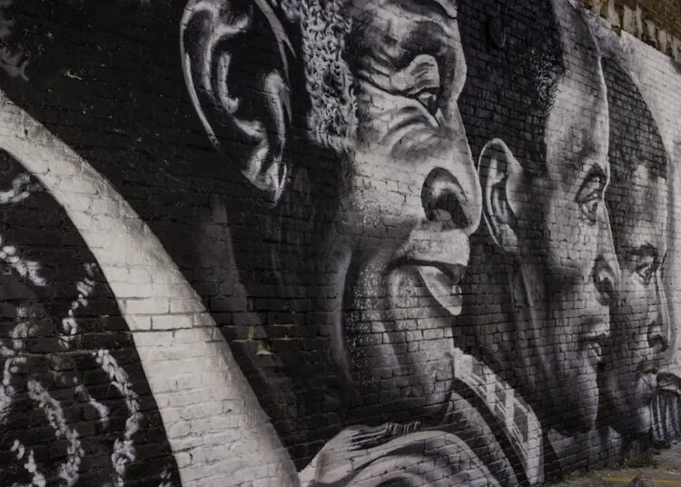 A new mural, depicting actor John Amos, Jr. (center), flanked by his father and son, located at 88 S. Front Street.