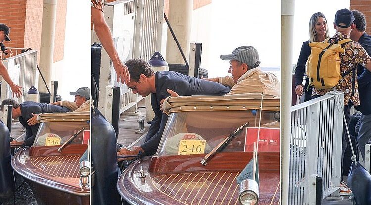 Jude Law, 51, takes a tumble and nearly drops his laptop in the water while stepping off a