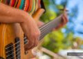 Person strum guitar at outdoor venue