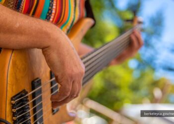 Person strum guitar at outdoor venue