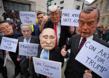 Protesters wear masks of politicians during a demonstration of the Stop Trump Coalition group in London. Some of the protesters are holding signs that read: