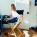 Princess Lilibet sitting in a directors chair turning to look at Daniel Martin peeking from a doorway