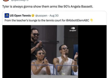 Group clapping in a tennis stadium box, including two people at the front wearing sunglasses. Twitter text references "Tyler" and "Angela Bassett."