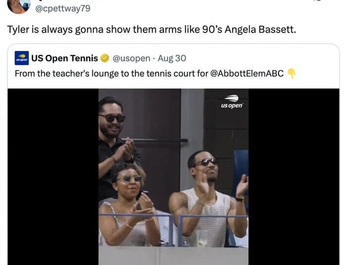 Group clapping in a tennis stadium box, including two people at the front wearing sunglasses. Twitter text references "Tyler" and "Angela Bassett."