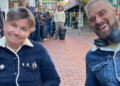Zoe Cutting and Simon Smith queuing outside Resident Music in Kensington Gardens, Brighton and Hove. Both are wearing button up jackets; Zoe's is corduroy and Simon's is denim. They are both sitting in camp chairs.