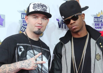 Paul Wall and Chamillionaire posing at a VH1 event, wearing casual hip-hop attire and hats.