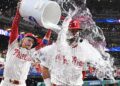 Sep 9, 2025; Philadelphia, Pennsylvania, USA; Philadelphia Phillies outfielder Kyle Schwarber (12) has water dumped on him by second base Bryson Stott (5) after win against the New York Mets at Citizens Bank Park. Mandatory Credit: Eric Hartline-Imagn Images