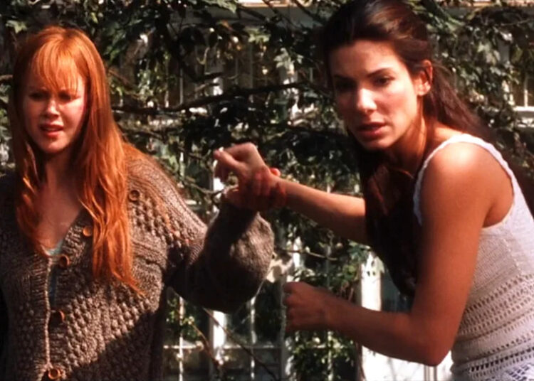 Nicole Kidman and Sandra Bullock as Gilly and Sally looking in backyard in disbelief in Practical Magic .