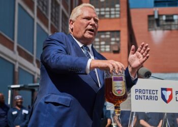 A man pours out a bottle of whisky