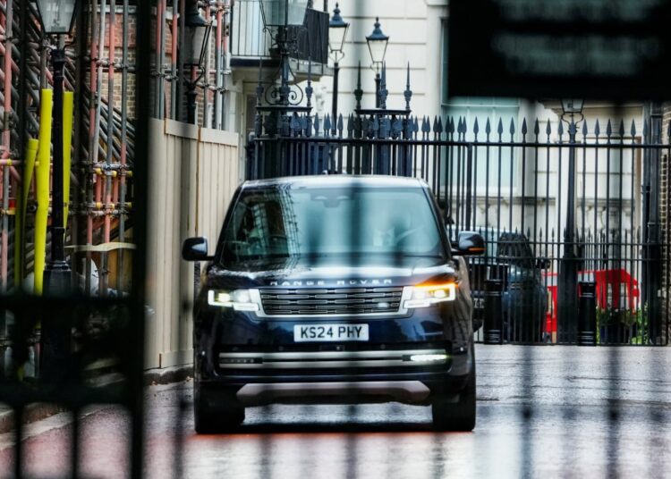 A black SUV drives down a street