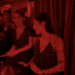 Princess Eugenie dancing in a red-hued room next to a woman