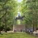 PA Media A mock-up of St James's Park with a large statue of Queen Elizabeth II on horseback high above ground. The statue sits on a plinth in between two rows of tall trees. People are milling about around it and on the pavement off to the right. It is daytime.