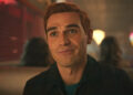 KJ Apa smiling as Archie while in Pop's in Season 7 of Riverdale .