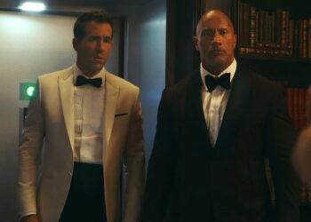 Dwayne Johnson and Ryan Reynolds in suits in Red Notice.