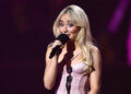 Sabrina Carpenter accepts an award on stage