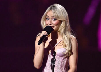 Sabrina Carpenter accepts an award on stage
