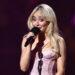 Sabrina Carpenter accepts an award on stage
