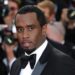 Sean “Diddy” Combs in a tuxedo on the red carpet at a formal event, posing for cameras