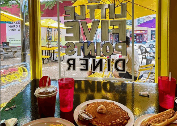 A spread of eggs, pancakes, and breakfast sandwiches beside the front window of Little Five Points Diner in Atlanta.