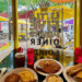 A spread of eggs, pancakes, and breakfast sandwiches beside the front window of Little Five Points Diner in Atlanta.
