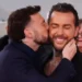 PA Media A man with short black hair kisses another man with long slicked black hair on his cheek.