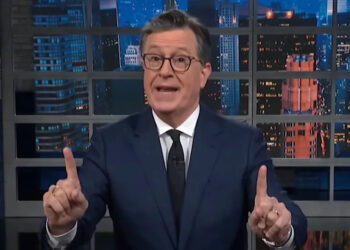 Stephen Colbert pointing up with both index fingers while giving monologue on The Late Show.