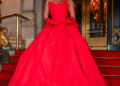 Sydney Sweeney wearing a dramatic red ball gown while posing on the steps outside