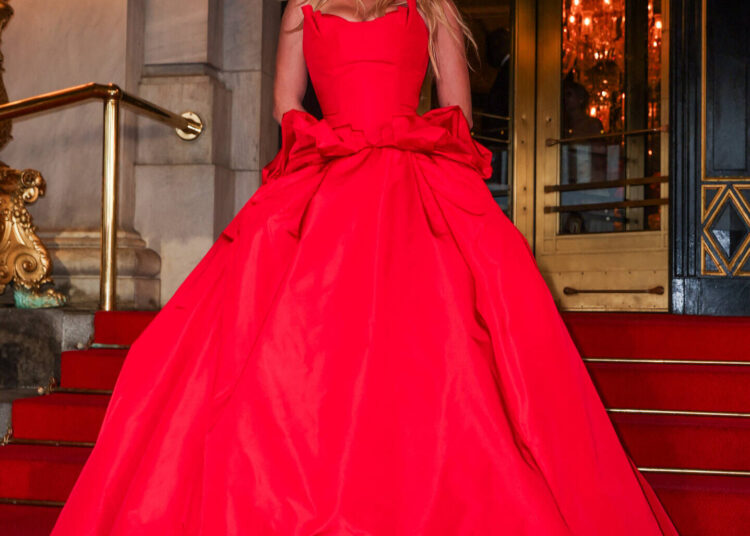 Sydney Sweeney wearing a dramatic red ball gown while posing on the steps outside