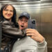 A man and woman hug while taking a selfie in a lift mirror