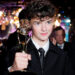 Owen Cooper poses with his trophy for best supporting actor in a limited series