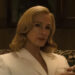 Julia Roberts sitting down in a white blazer and a drink in hand in After The Hunt.