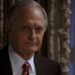 Alan Alda in a suit, looking very serious on The West Wing.