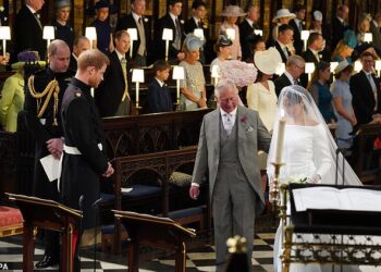 Prince Harry looking at his bride, Meghan Markle, as she arrives, accompanied by the Prince of Wales, in St George's Chapel at Windsor Castle for their wedding