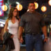 From left to right: Emily Blunt walking and holding hands with Dwayne Johnson in The Smashing Machine. .