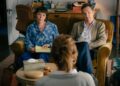 A man and woman sit in front of a woman.