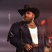 Teddy Swims performs on stage in a cowboy hat.