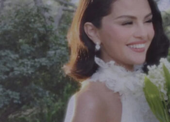 woman in a formal dress holding flowers outdoors