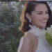 woman in a formal dress holding flowers outdoors