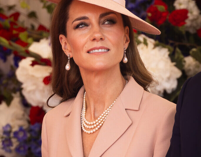 The Princess of Wales (Kate) wears pale pink Dior as she stands in front of red, white and blue flowers at the official welcome at the start of the State Visit to the UK by President Macron of France