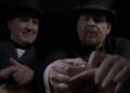 Two men in bowler hats inspecting a corpse in Dead Man's Gun