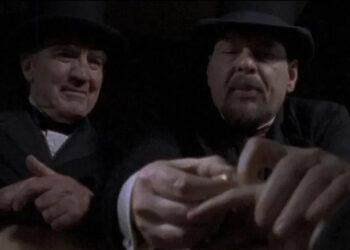 Two men in bowler hats inspecting a corpse in Dead Man's Gun