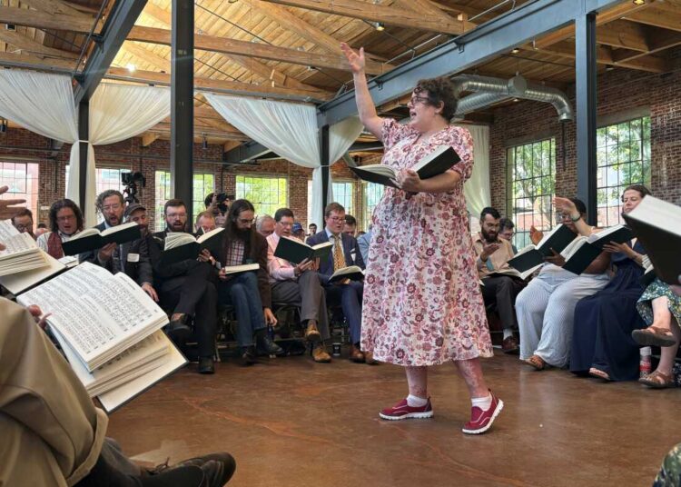 Musicologist Angharad Davis of Australia leads the song she composed for the new edition of The Sacred Harp, "Radiance," in the center of the hollow square.