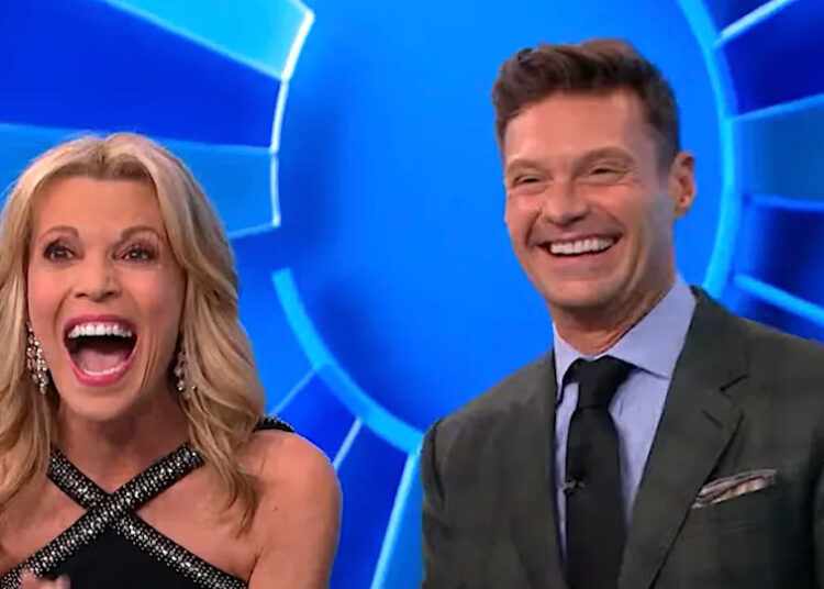 Vanna White and Ryan Seacrest smiling big on Wheel of Fortune.