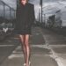 victoria beckham standing on a sidewalk in a dark blazer and high heels