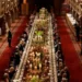 PA A long dining table with dignitaries seated down either side is seen in a banquet hall, with staff and press against the walls.