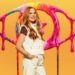 Patsy Palmer wearing a white two piece and brown t-shirt, smiling ahead.