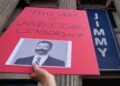 A demonstrator holds a sign outside El Capitan Entertainment Centre, where the late-night show "Jimmy Kimmel Live!" is staged on Thursday, Sept. 18, 2025, in Los Angeles. (AP Photo/Damian Dovarganes)