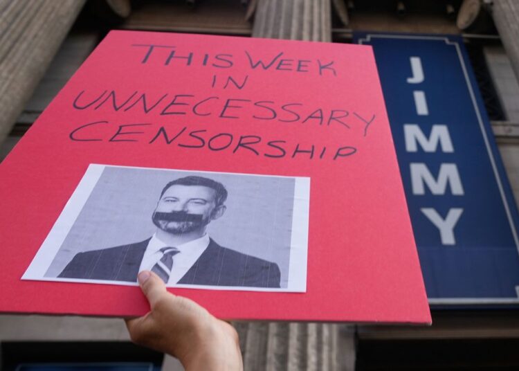 A demonstrator holds a sign outside El Capitan Entertainment Centre, where the late-night show "Jimmy Kimmel Live!" is staged on Thursday, Sept. 18, 2025, in Los Angeles. (AP Photo/Damian Dovarganes)